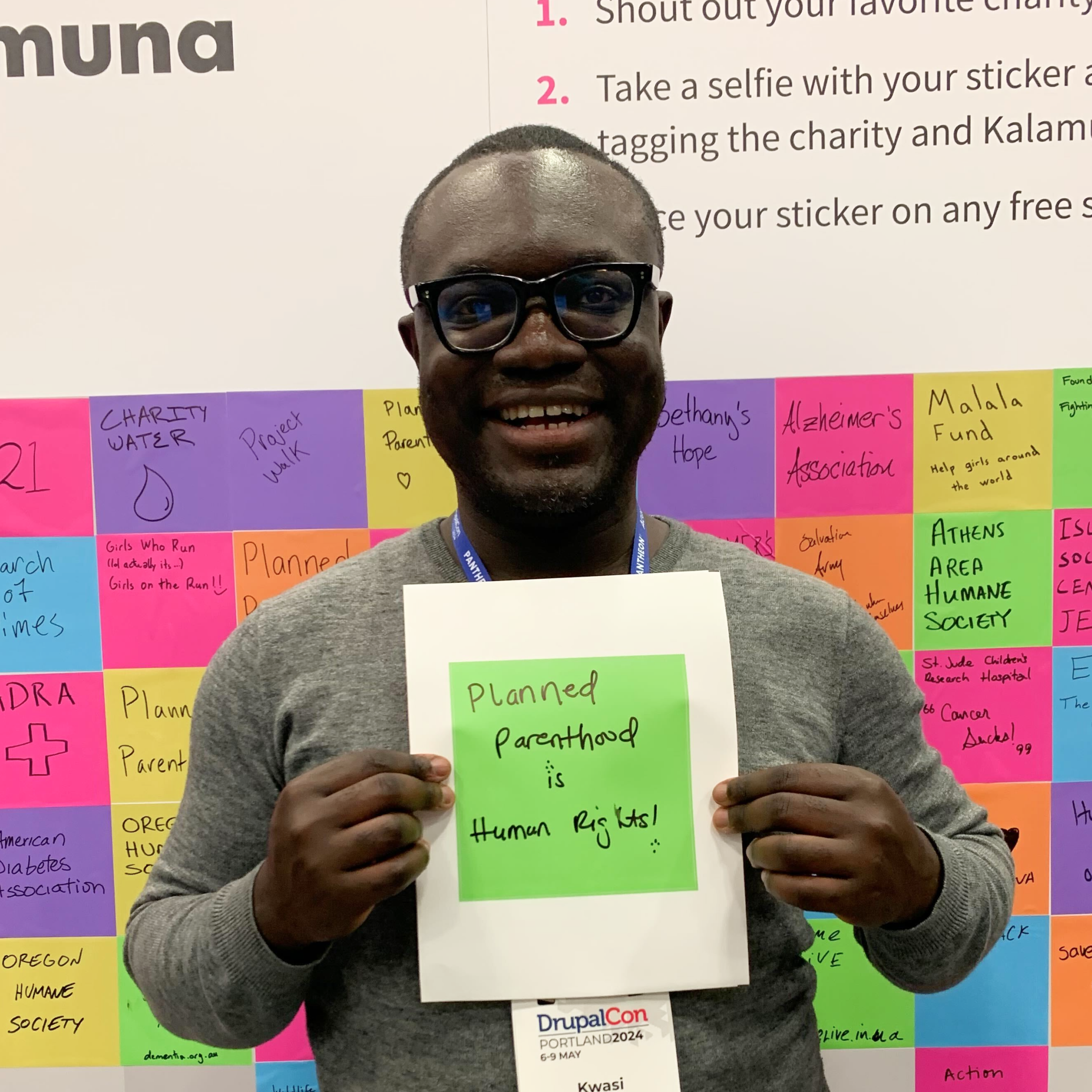 Kwasi Afreh holds a green square sticker with "Planned Parenthood is Human Rights!" written on it.